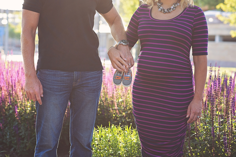 pregnant mom and dad to be holding hands with little baby boy shoes in ohio maternity session