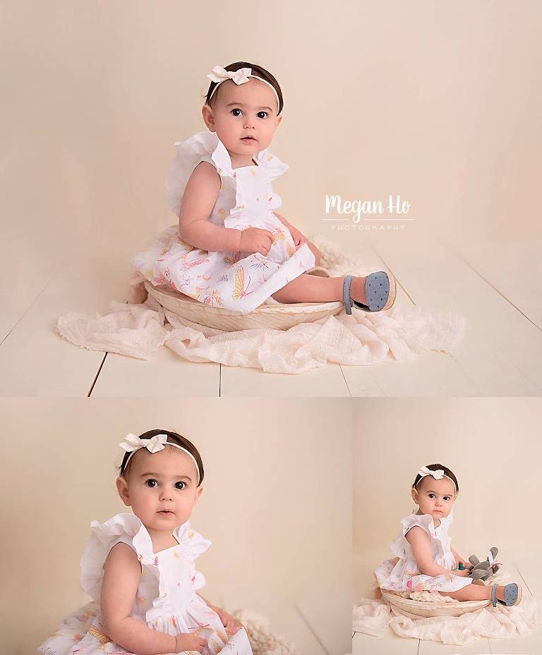 pretty baby girl sitting in a white bowl in dress in one year milestone session nh