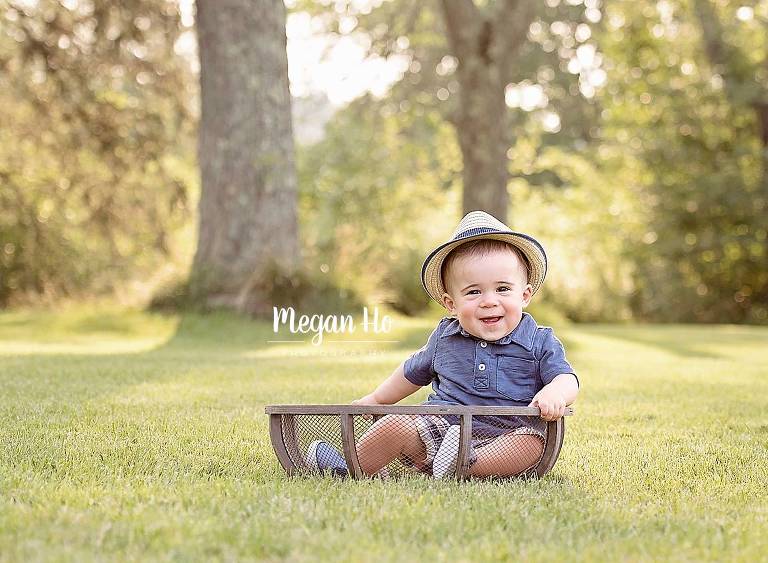one year little boy in wooden bowl in hat in field in southern nh