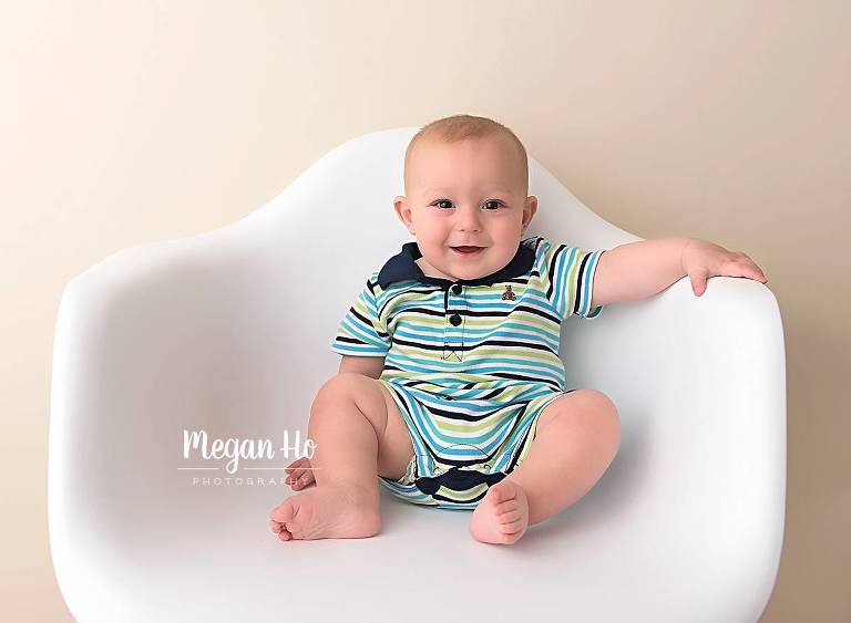six month old baby boy sitting in white chair nh studio session
