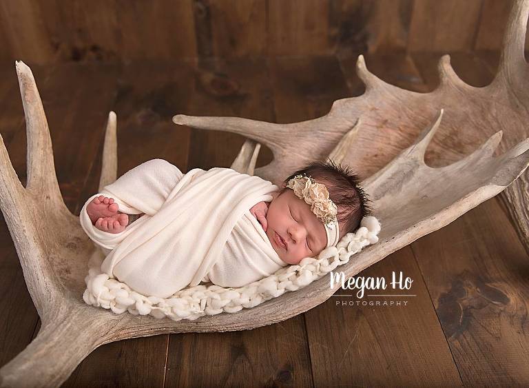 beautiful baby wrapped girl sleeping on moose antlers bedford new hampshire