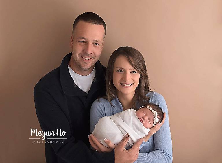adorable wrapped baby girl in nh snuggling with mom and dad
