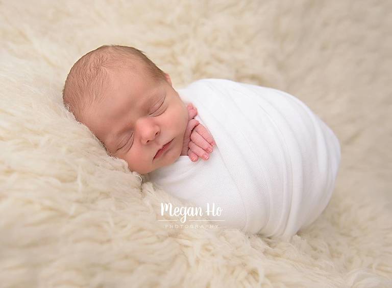 wrapped baby boy on fluffy rug in southern new hampshire session
