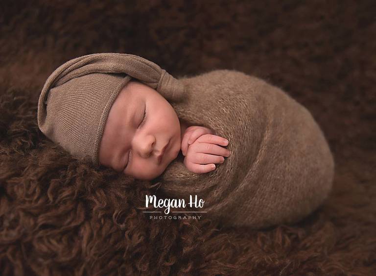 cute sleeping boy wrapped in boy on brown fluffy rug in nh session