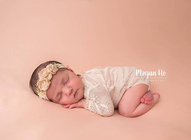sweet newborn girl in lace outfit on peach backdrop in nh studio