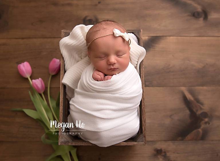 wrapped baby girl in crate with pink tulips southern nh