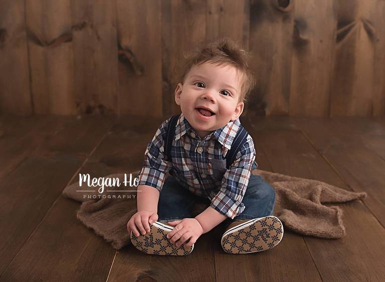 sitting boy on wood floor in little suspenders and shoes in nh studio