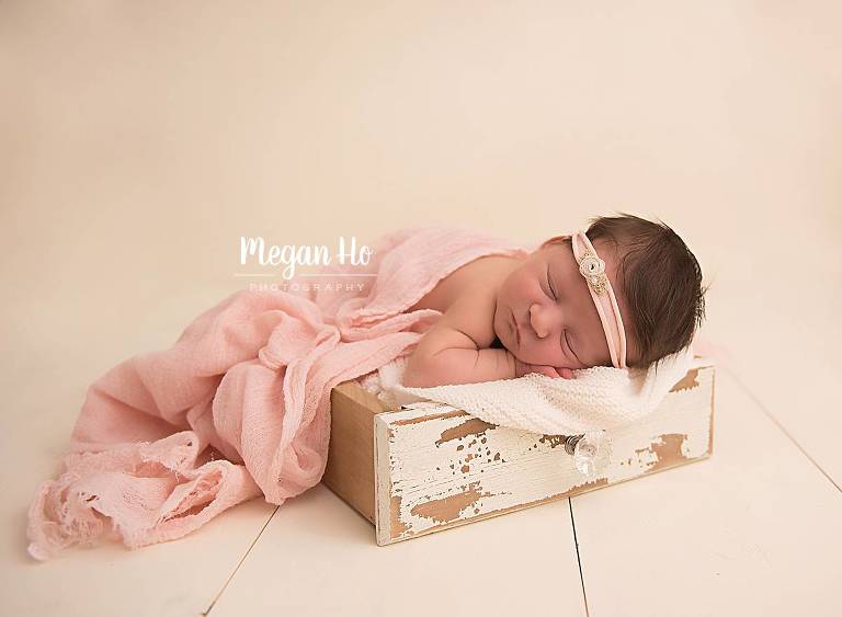 nh newborn girl sleeping in antique wood drawer on white wood