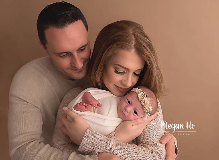 mom and dad snuggling brand new baby girl nh studio session