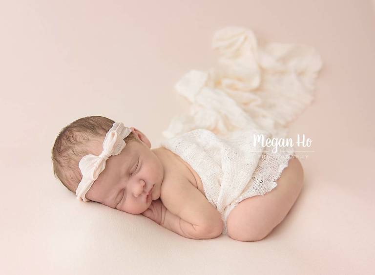 sleeping baby girl on blush blanket covered in lace