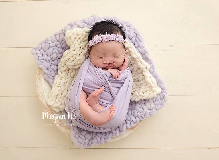 sleeping baby girl with cleft palate wrapped in purple on two bump blankets in southern nh