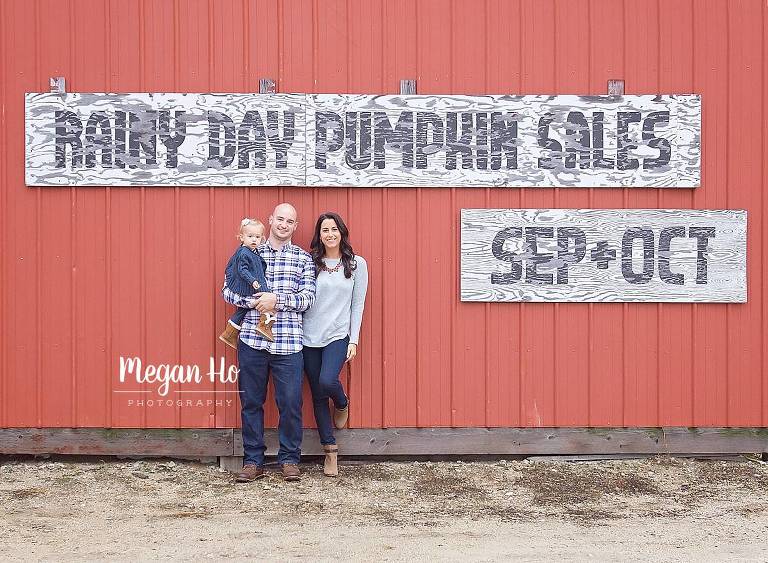 family standing in front of red barn in southern nh outdoor session