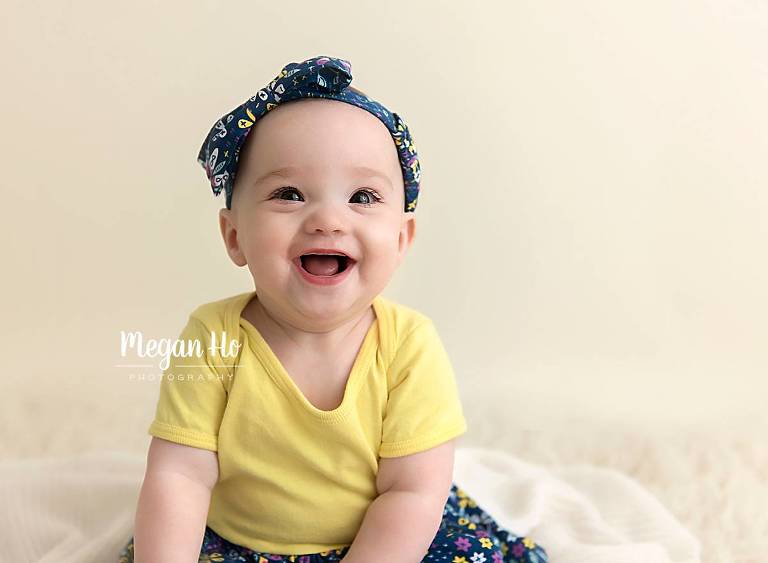 close up of smiling 6 month girl face dressed in yellow in southern nh session