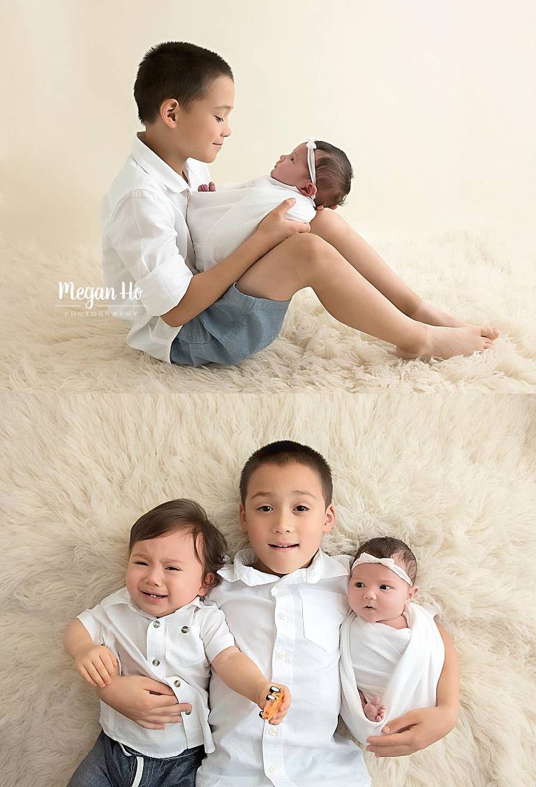 Big brother siblings with adorable baby sister on white rug
