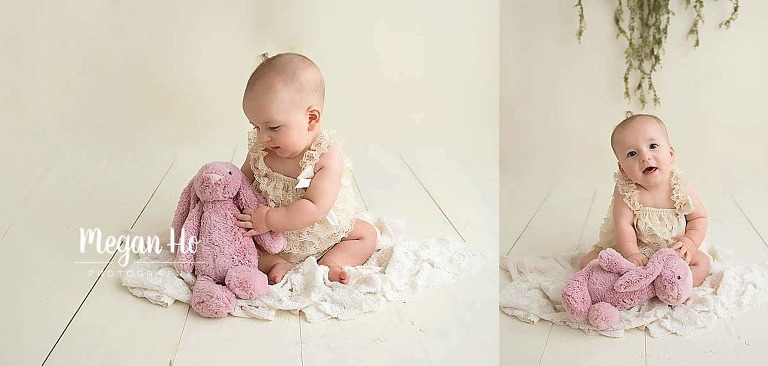 adorable baby girl sitting up on wood floor with light pink bunny