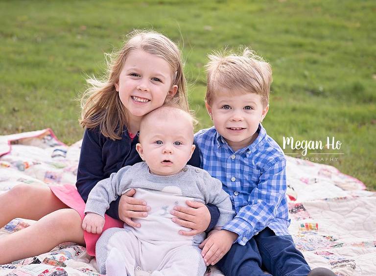 three kids sitting on a quilt in hollis nh family session