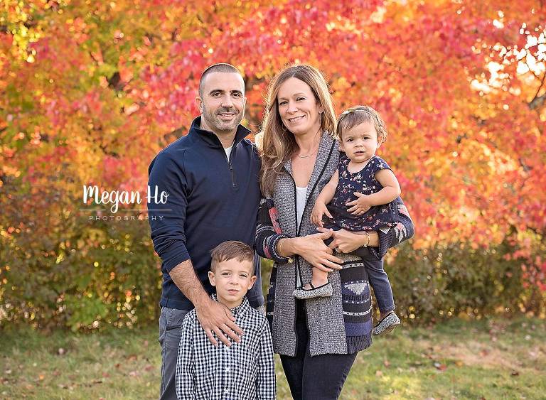beautiful family of four in front of beautiful fall trees in southern nh