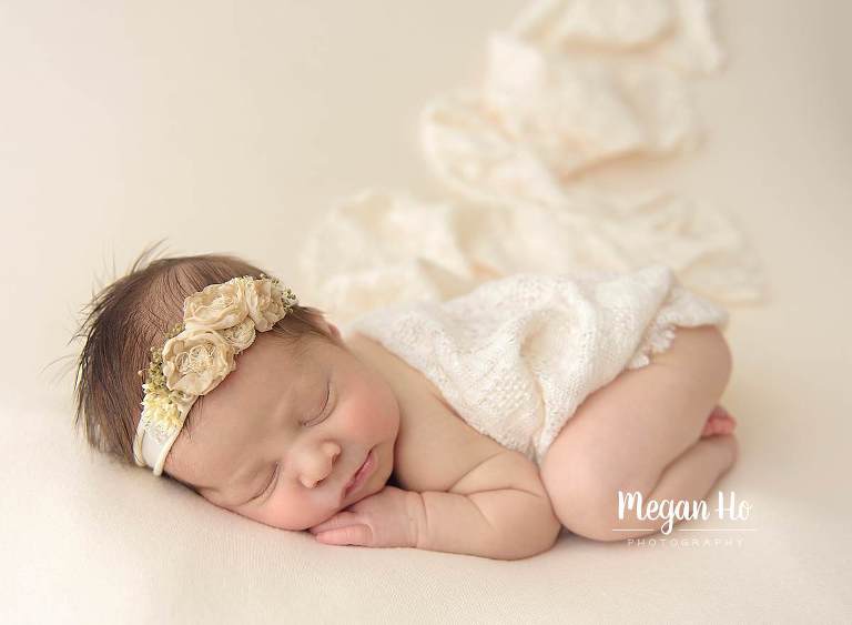 adorable sleeping little girl on cream with lace blanket in nh session