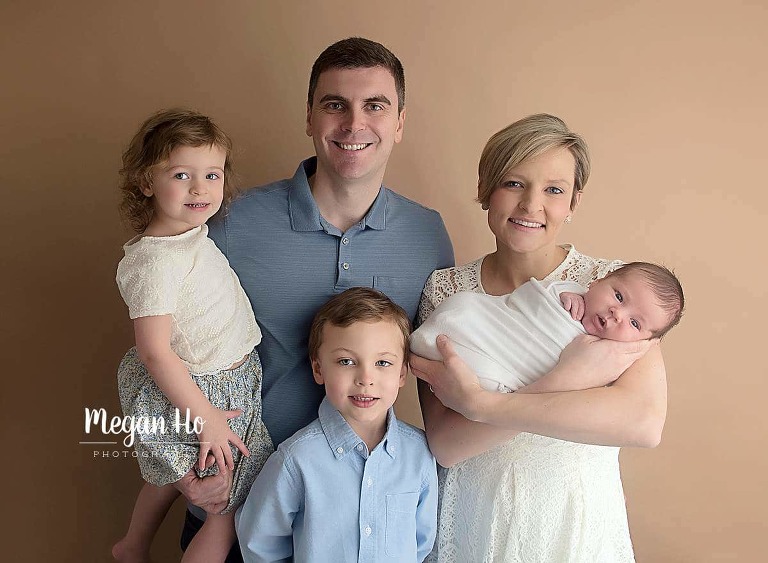 family of five in white and blue in newborn session for baby boy