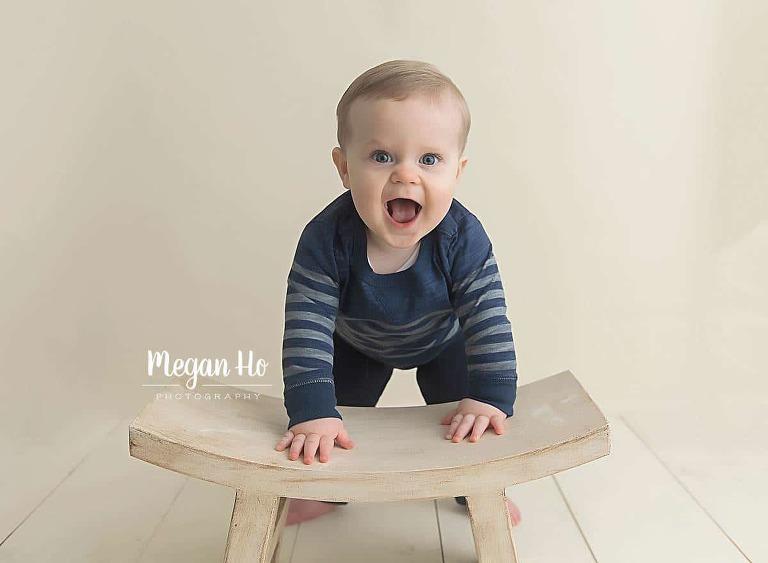 little boy in nh studio pushing up on white stool with happy face