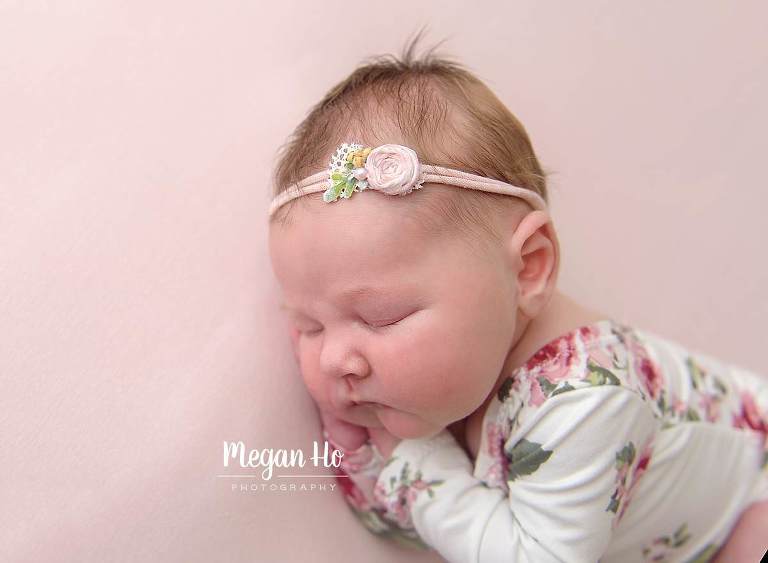 beautiful sleeping baby girl with chubby cheeks in flower romper