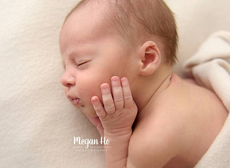 baby fingers resting on baby boys cheeks in nh