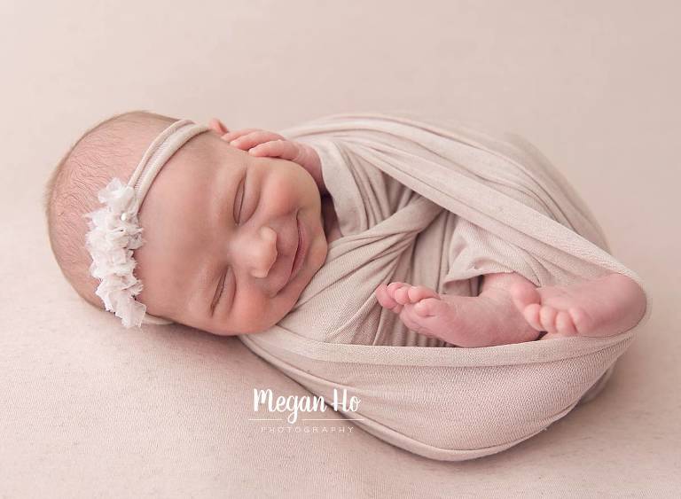 wrapped up tight in pink smiling newborn girl