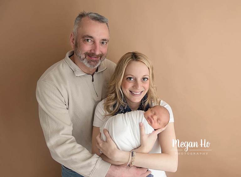 nh newborn session mom and dad happily snuggling baby boy