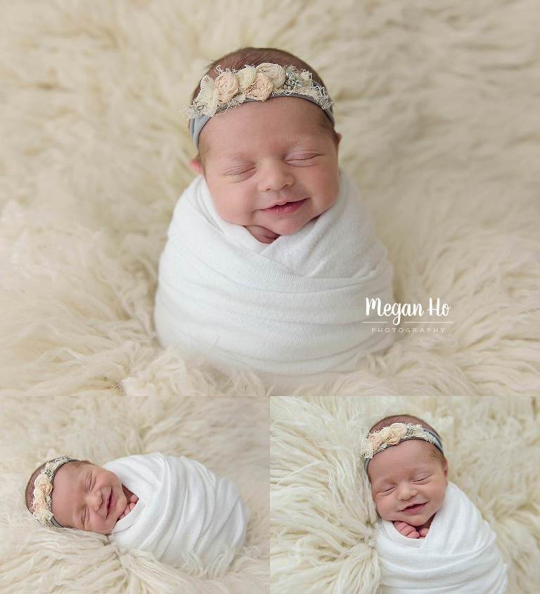 wrapped up sleeping and smiling little girl on white fluffy rug