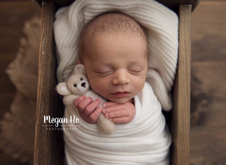 adorable baby boy in white sleeping holding tiny tan bear in bedford nh