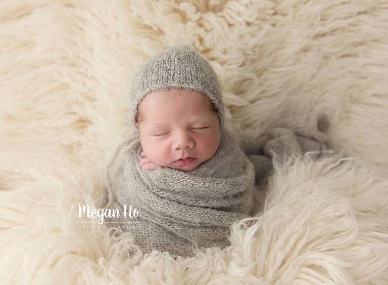 baby boy wrapped in grey knit wrap and bonnet in bedford nh