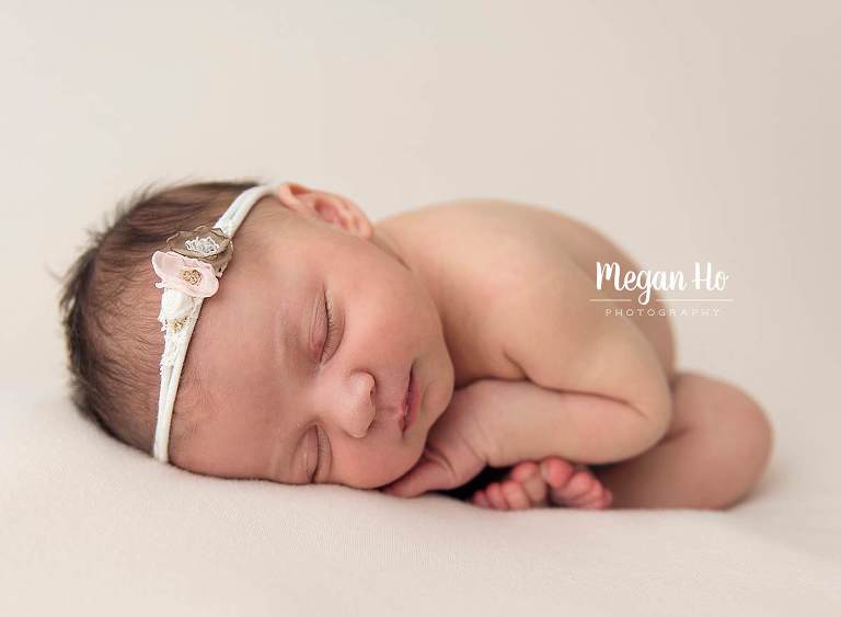 taco pose little girl curled over toes with adorable white and pink bow