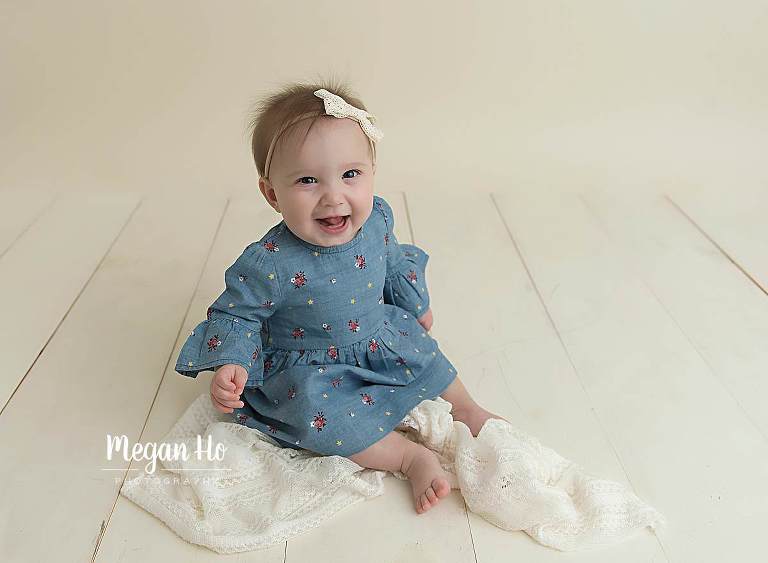 smiling girl in blue dress on white wood floor in nh studio