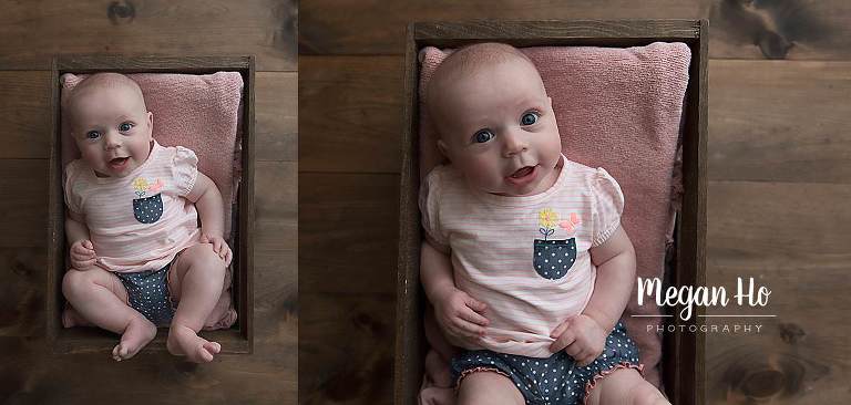 baby girl in pink and blue laying in wooden crate