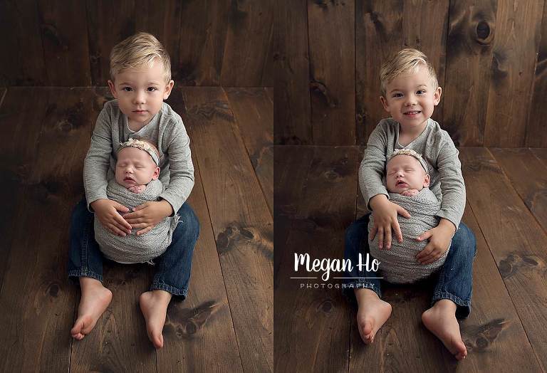 adorable big brother sitting with baby sister on wood floor in grey