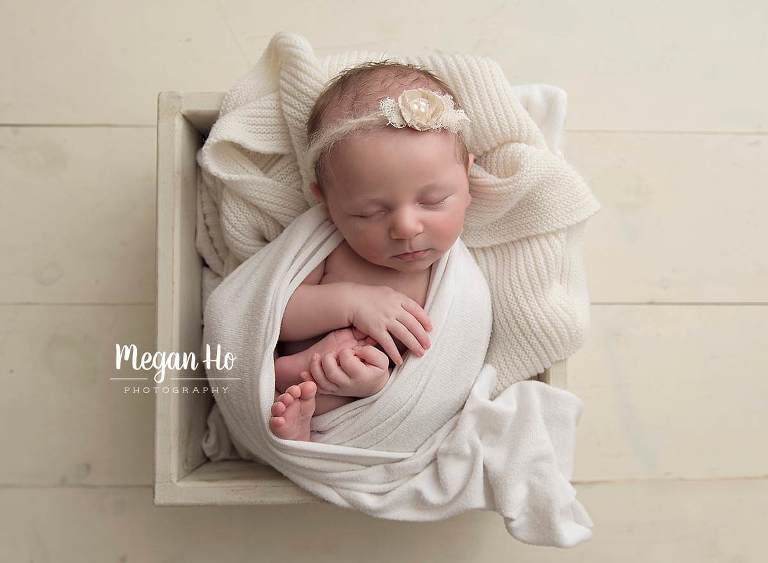 adorable baby girl wrapped in white sleeping in white box southern New Hampshire