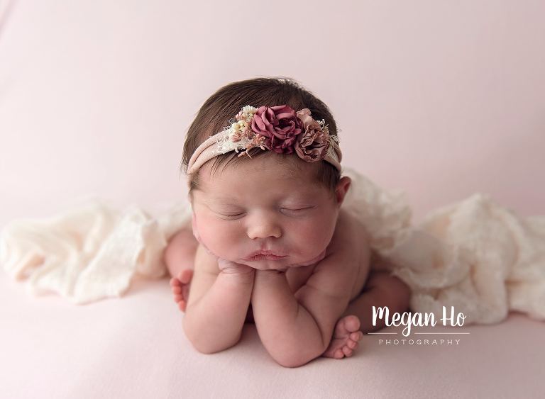 little girl in froggy pose on pink blanket in newborn session