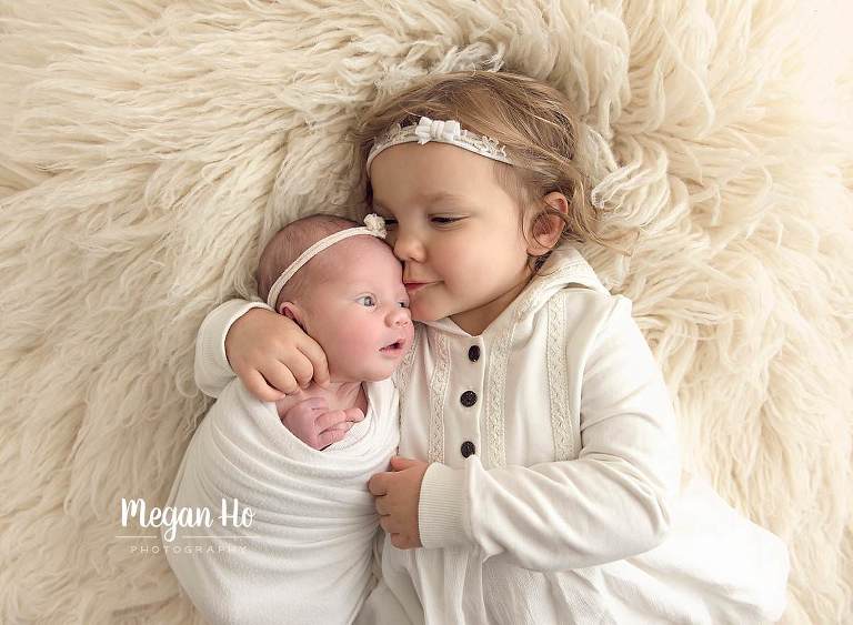 big sister kissing her baby sibling in nh studio session