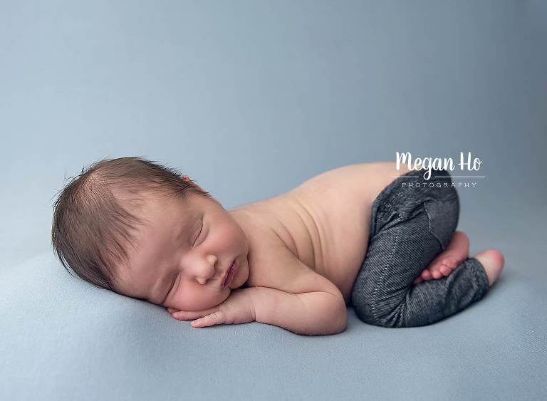 sweet little boy in baby jeans sleeping on blue beanbag