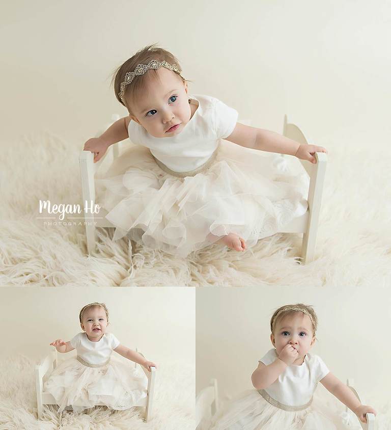 milestone session baby girl in white dress sitting on little bed