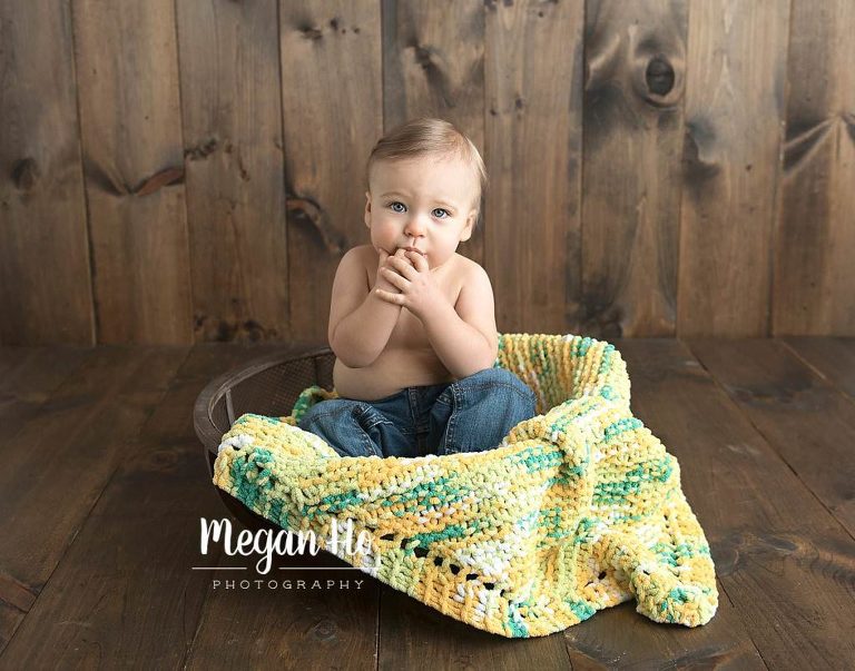 One year old sitting in bowl with blanket made by family