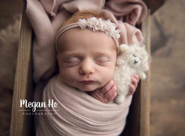 adorable baby girl with red hair snuggling white little lamb in New Hampshire