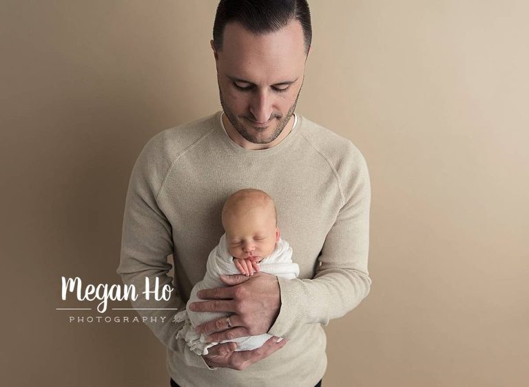 dad holding his adorable newborn son in bedford nh studio