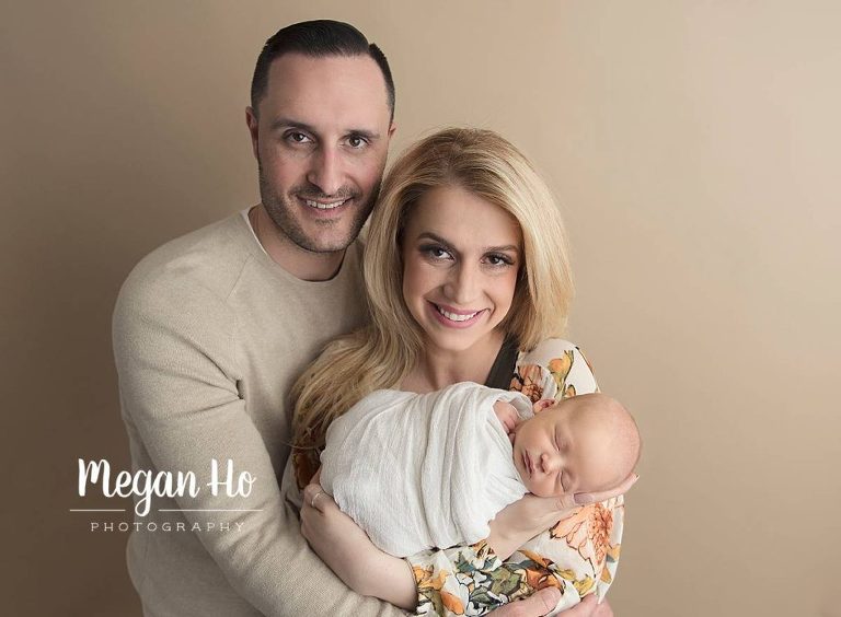 beautiful family holding newborn baby son in neutrals