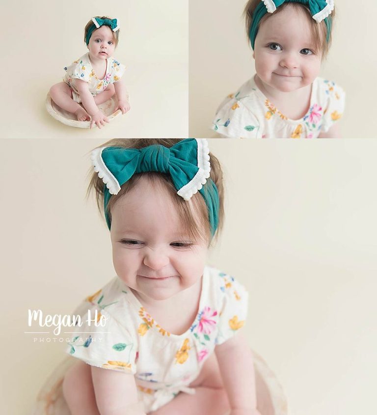 adorable faces of one year girl with headband on cream backdrop