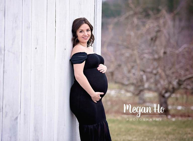 new Hampshire mama to be in black dress against white barn