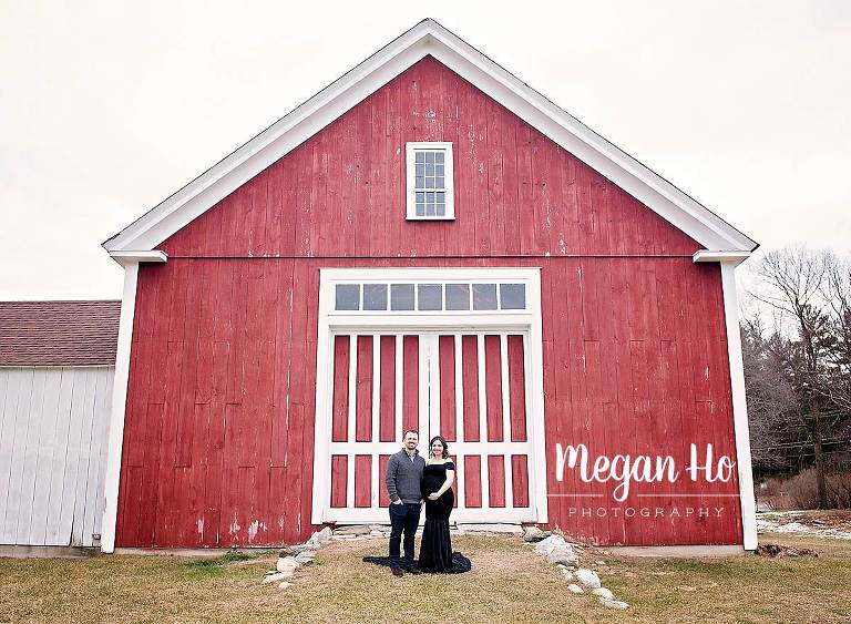 maternity couple excited posed in front of red barn in southern nh