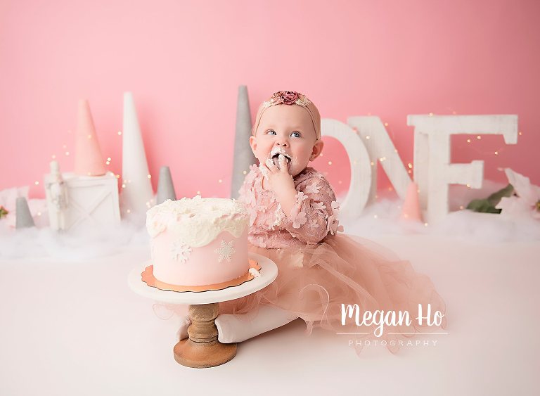 happy one year old eating cake in adorable session